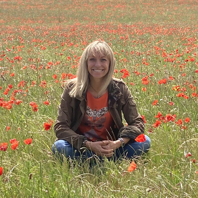 Michaela Strachan sitting in a poppy field