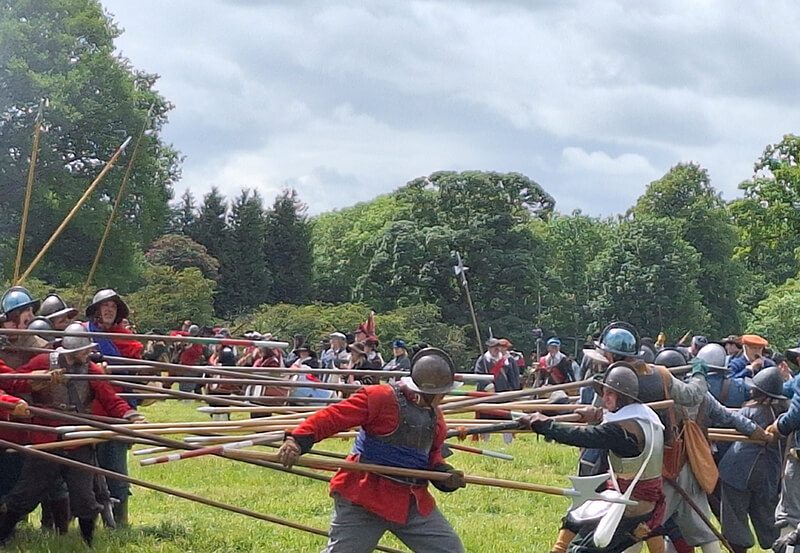 Members of the Sealed Knot re-enactment society in Civil War costume re-enacting the Battle of Naseby. There are two sides fighting with long wooden pikes