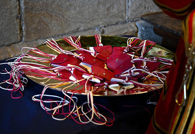Red and white leather purses arranged in a gold dish ready to give out at the Royal Maundy Service. Image copyright Alamy